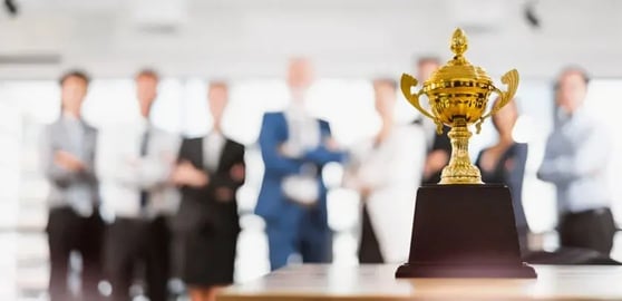 troféu em destaque com executivos em segundo plano, fora de fora. 
