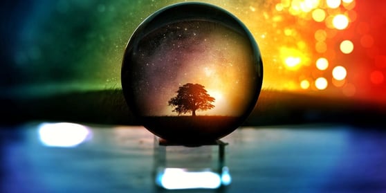 Crystal ball resting on stand, with water in the background.